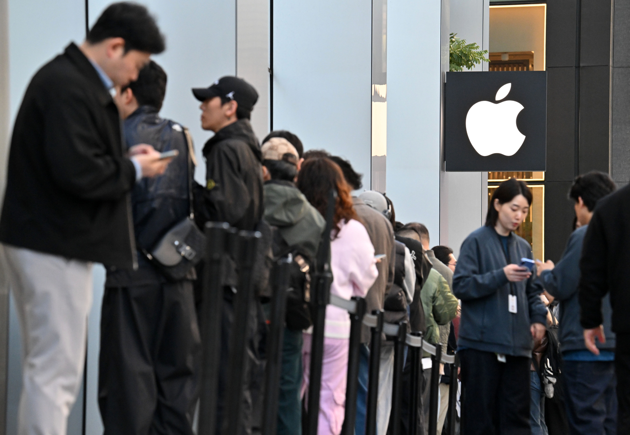 Customers line up outside Apple Myeongdong in central Seoul on Friday morning to collect the iPhone Duo, Apple's first foldable smartphone. (Im Se-jun/The Korea Herald)