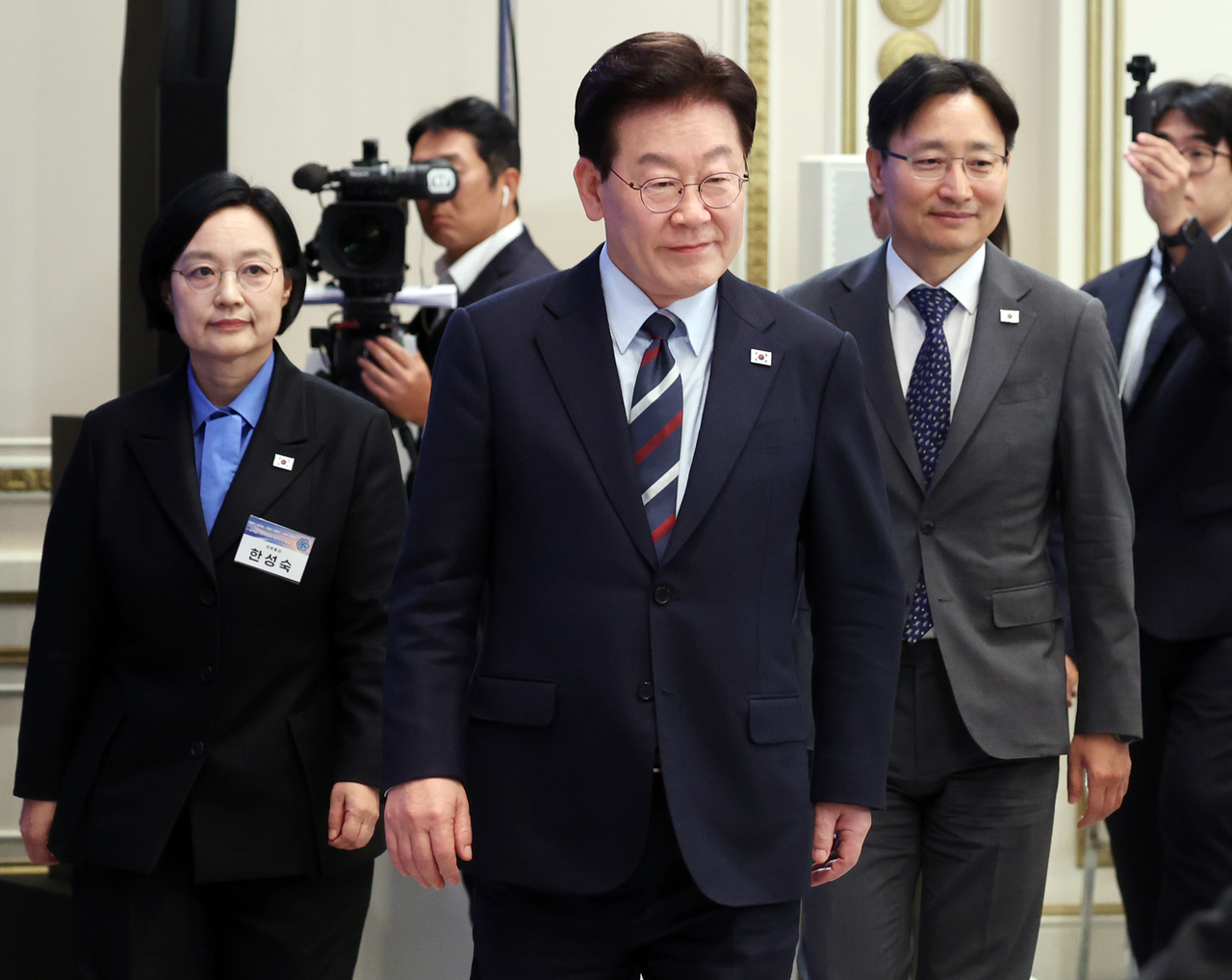 President Lee Jae Myung enters the second plenary session of the Regulatory Rationalization Committee at Cheong Wa Dae on Friday, accompanied by Prime Minister Han Seong-sook and Chief of Staff Lim Gwang-hyeon. [Yonhap]