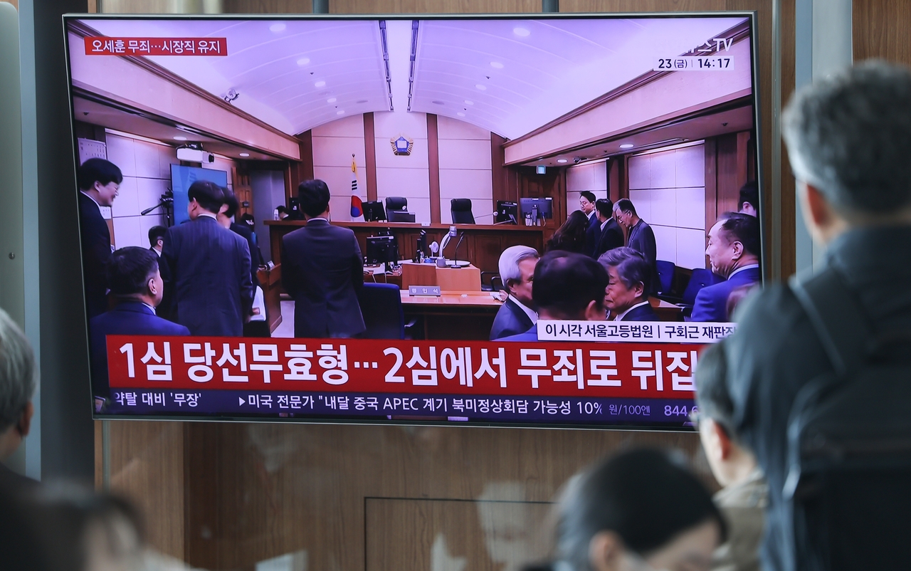 People gather at Seoul Station in Yongsan-gu, Seoul, to watch news reports as Seoul Mayor Oh Se-hoon is acquitted in the appellate ruling in his trial on charges of violating the Political Funds Act. (Yonhap)