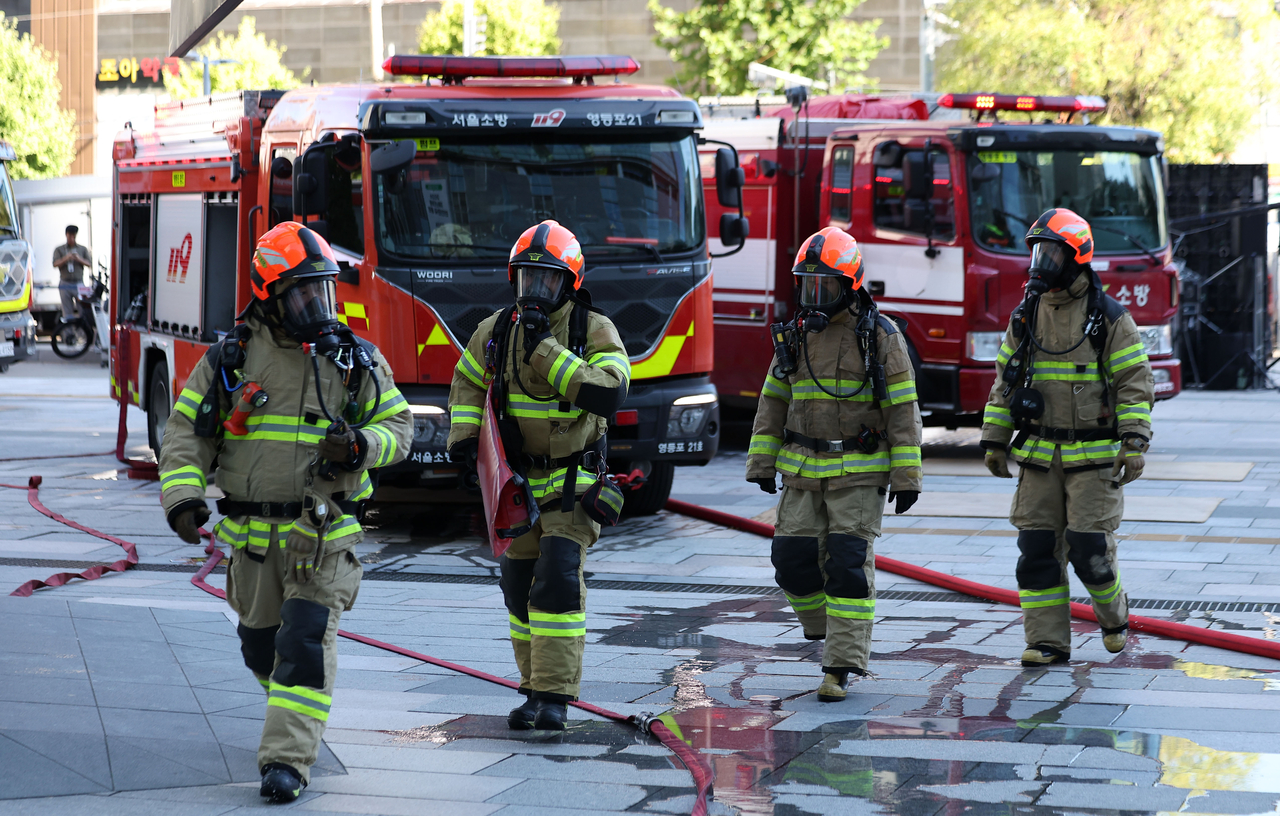 Firefighters conduct an emergency response drill at a large shopping mall in Seoul in September. [Newsis]