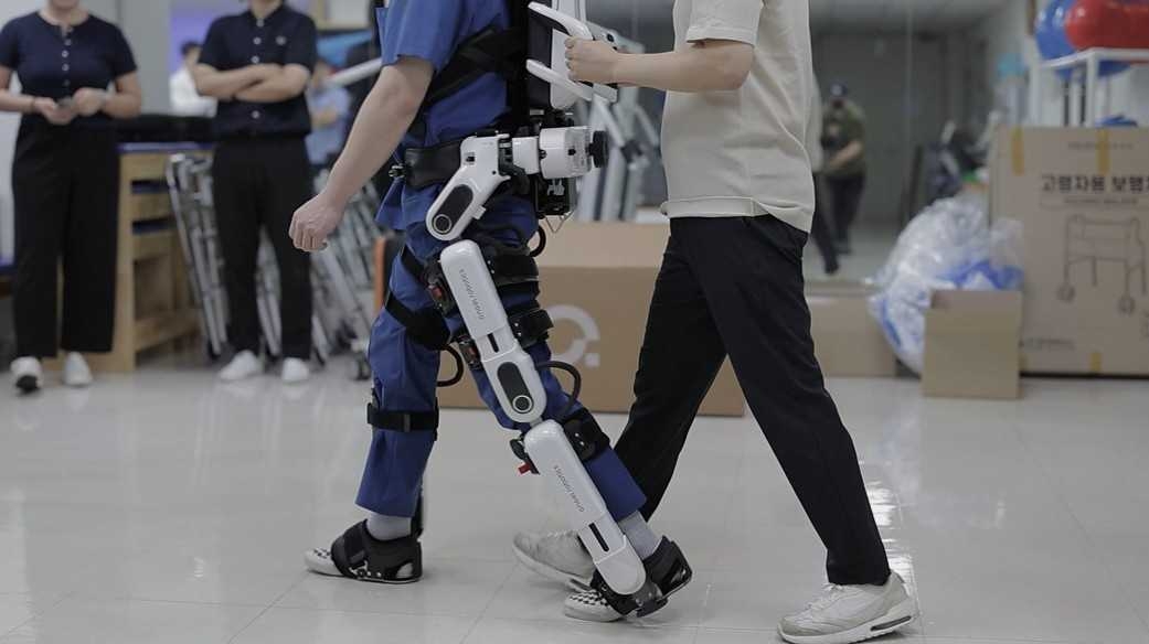 A recipient of the Posco 1% Sharing Foundation's advanced mobility assistance program practices walking with a robotic exoskeleton during a rehabilitation session. (Posco Group)