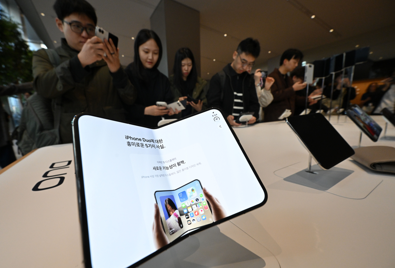 Customers examine the iPhone Duo at Apple Myeongdong in central Seoul on Friday. (Im Se-jun/The Korea Herald)