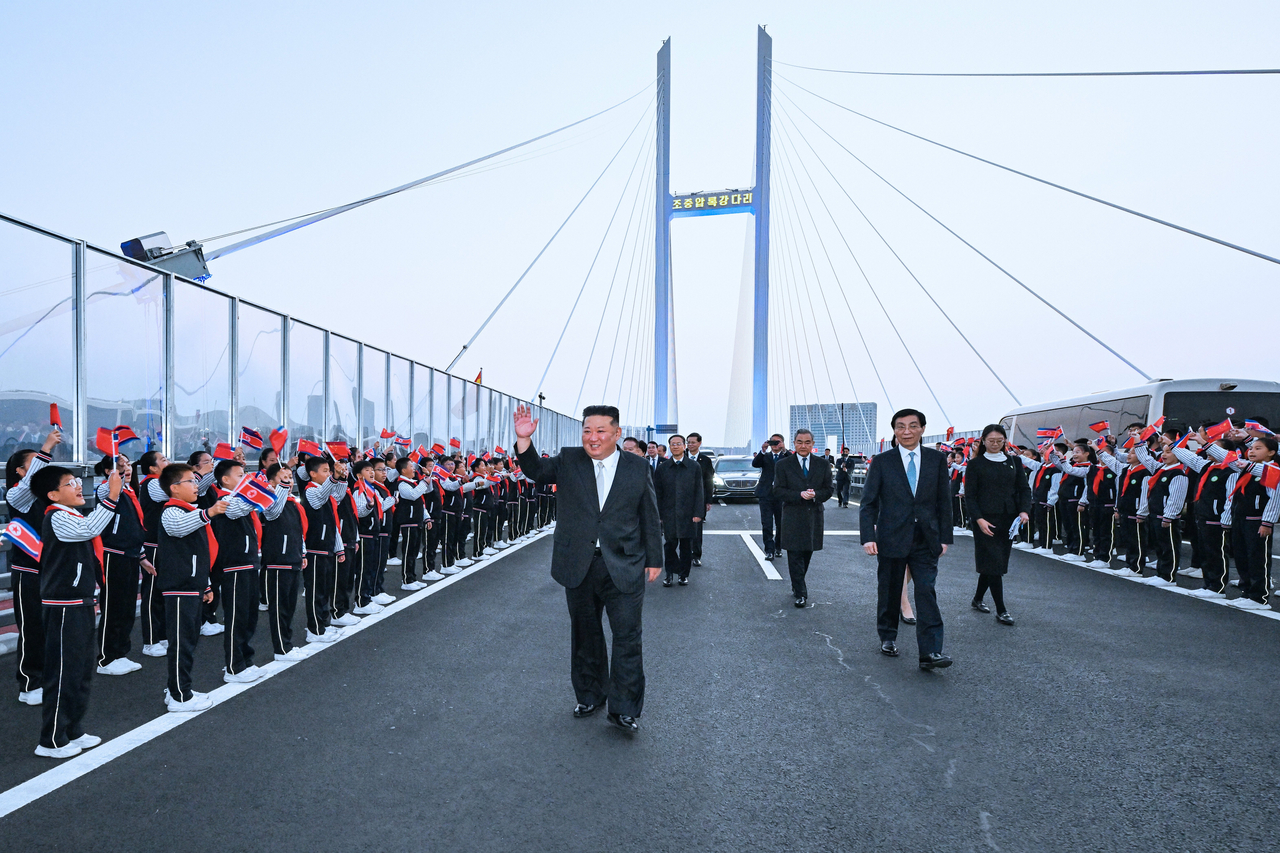 In this photo released by Xinhua News Agency, North Korean leader Kim Jong-un (left) is accompanied by Wang Huning, a member of the Standing Committee of China's Communist Party (second from right) and Chinese Foreign Minister Wang Yi, (third from right) during a see-off ceremony at the new Yalu River Bridge after Kim's visit to Dandong, northeast China's Liaoning province on Oct. 24, 2026. (Xinhua via AP-Yonhap)