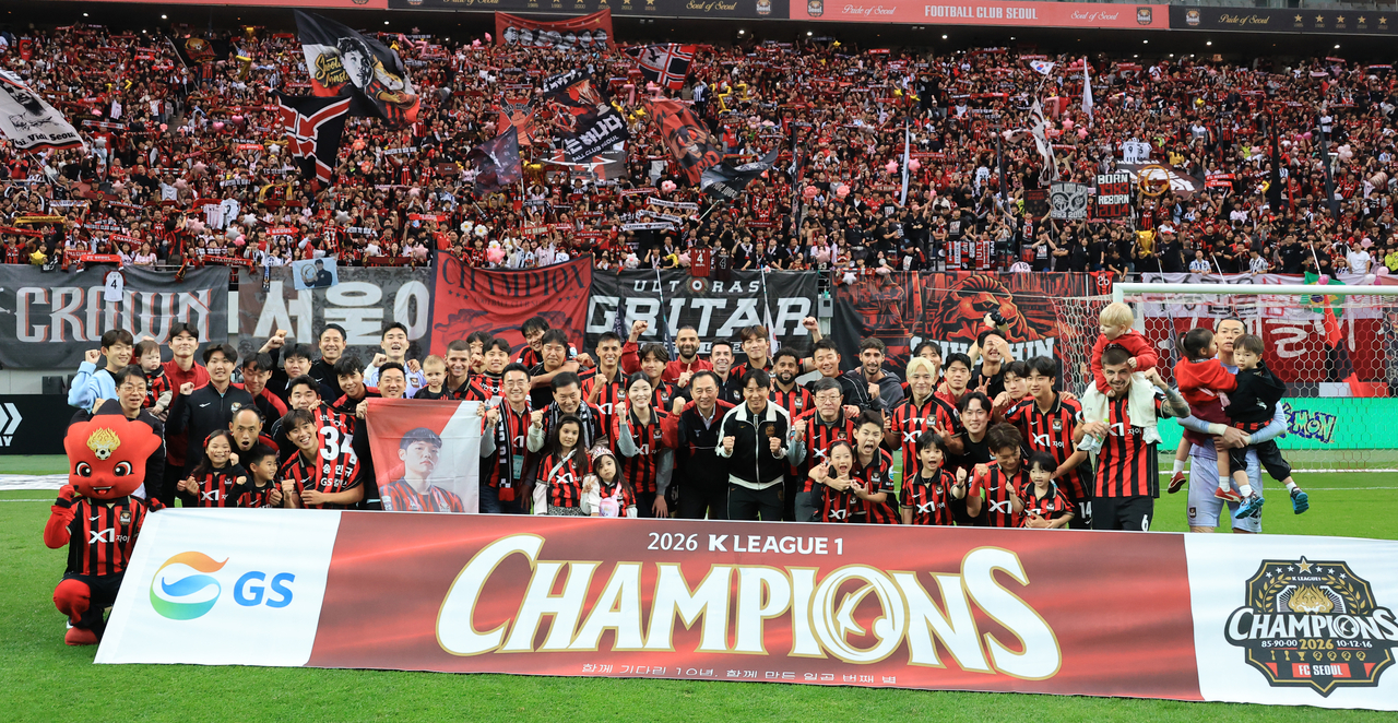 FC Seoul players and coaches celebrate with their K League 1 championship banner after a 1-1 draw against Gangwon FC at Seoul World Cup Stadium in Seoul on Saturday. (Yonhap)