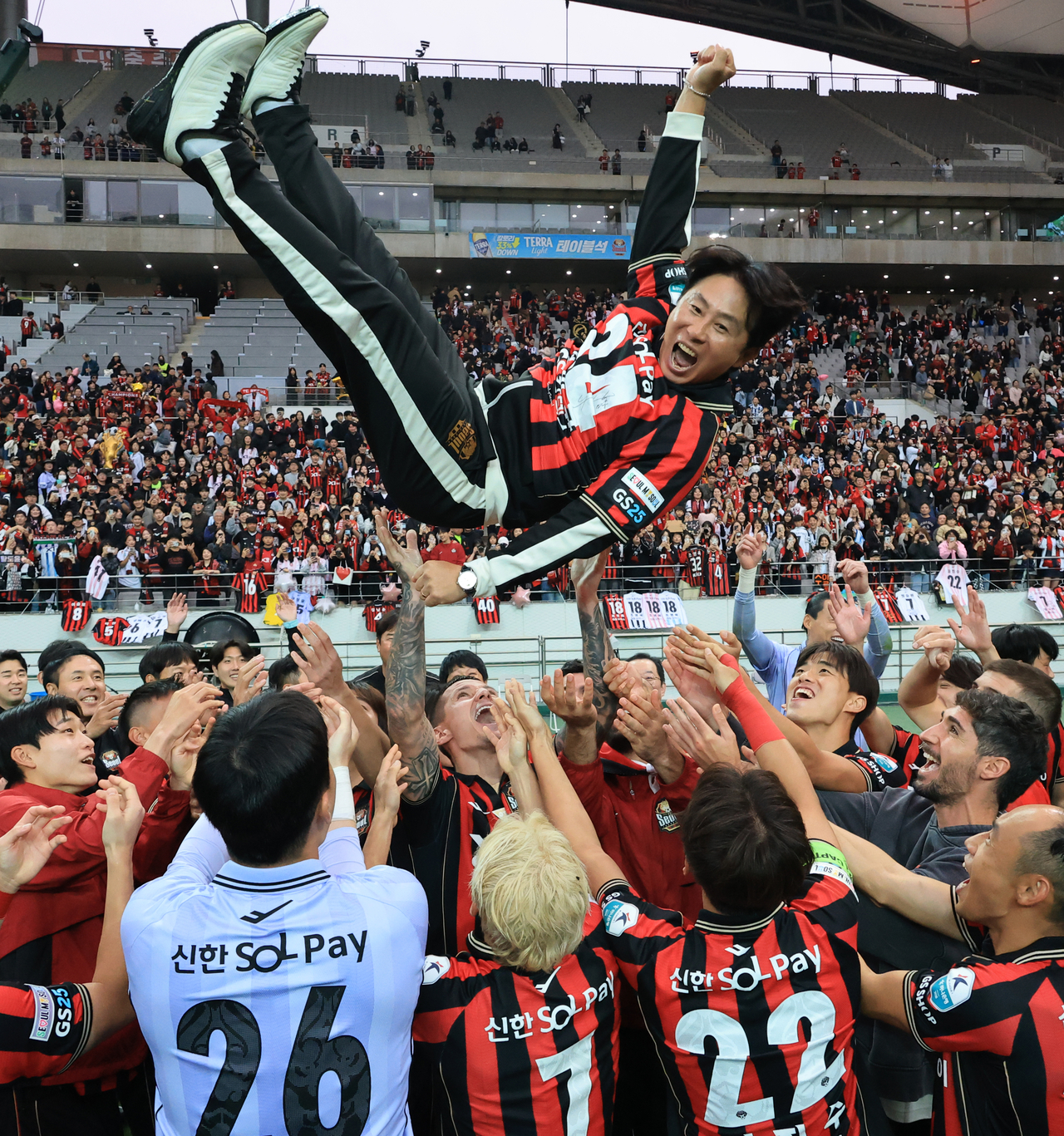 FC Seoul players toss their head coach Kim Gi-dong in the air to celebrate their K League 1 title following a 1-1 draw against Gangwon FC at Seoul World Cup Stadium in Seoul on Saturday. (Yonhap)