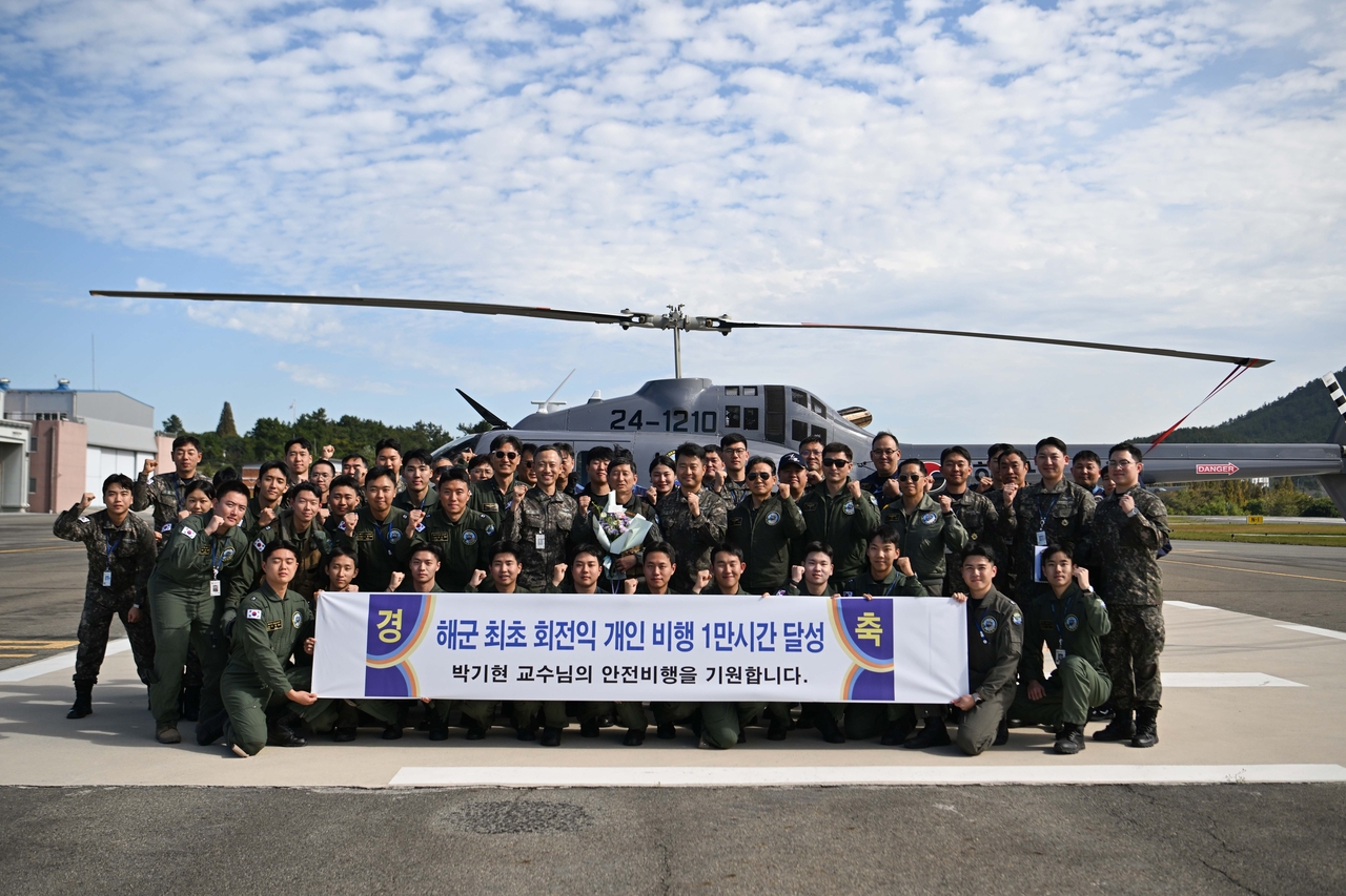 23일 박기현 해군항공사령부 609교육훈련전대 비행교육교관이 해군 최초로 ‘1만 시간 무사고 비행’을 달성하고 목포기지 주기장에서 부대원들과 기념사진을 촬영하고 있다. [해군 제공]