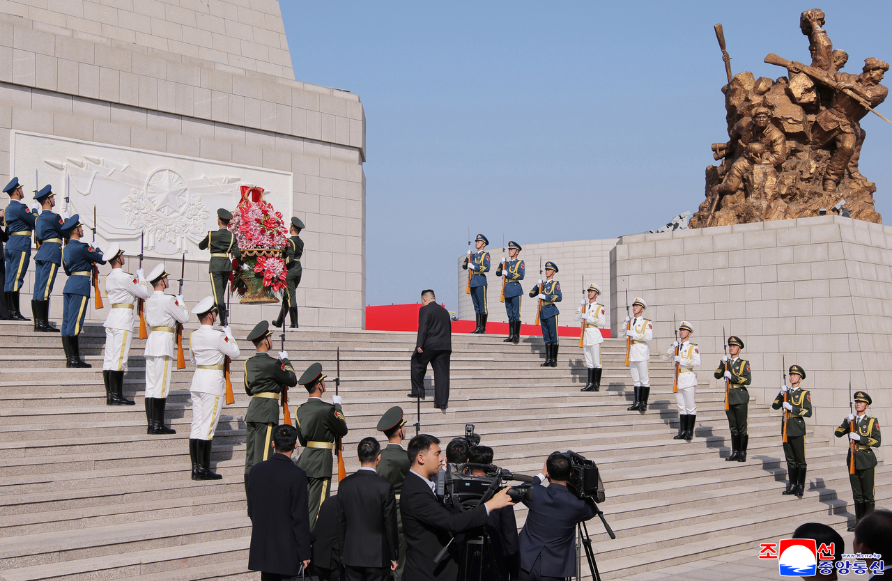 North Korean leader Kim Jong-un walks up the steps to a memorial honoring Chinese soldiers in Dandong, China, as soldiers carry a wreath on Oct. 24. (KCNA)