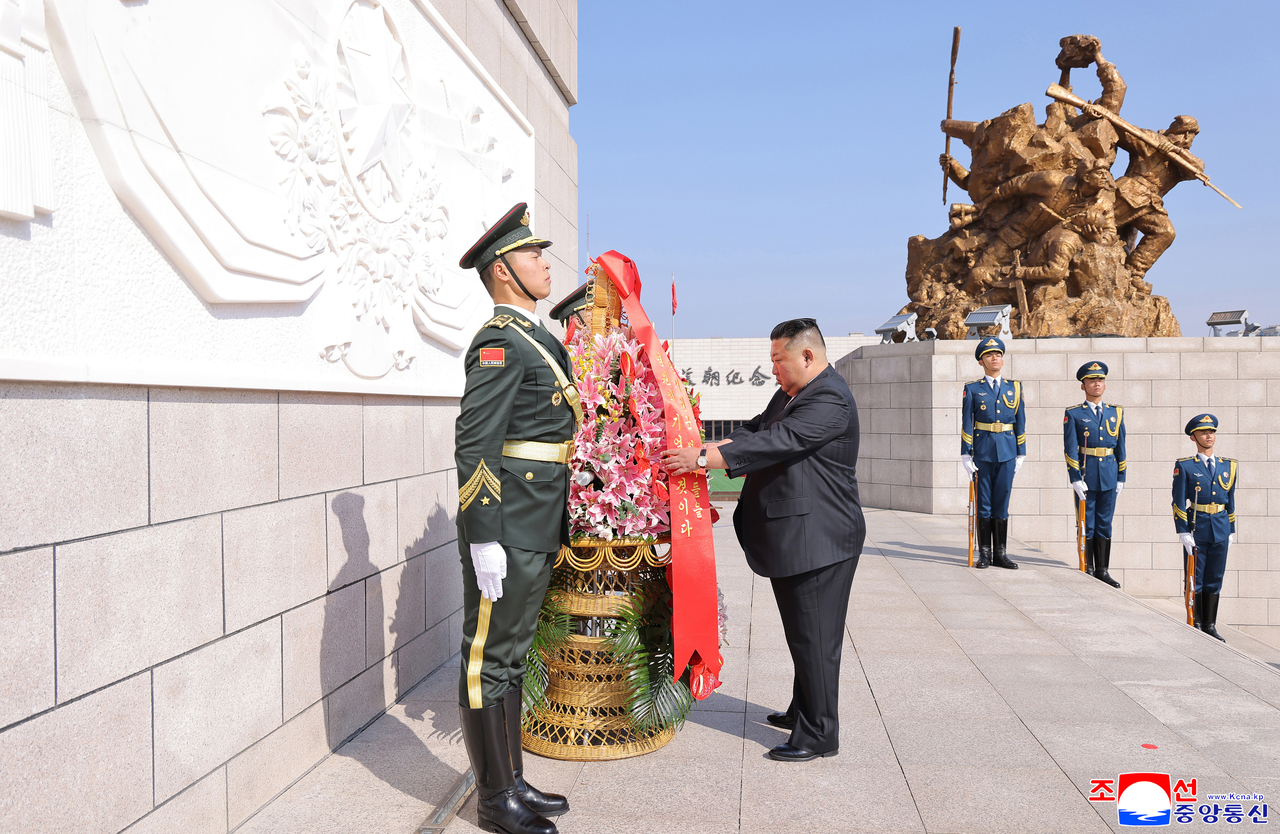 North Korean leader Kim Jong-un fixes the wreath placed at the memorial on Oct. 24. (KCNA)