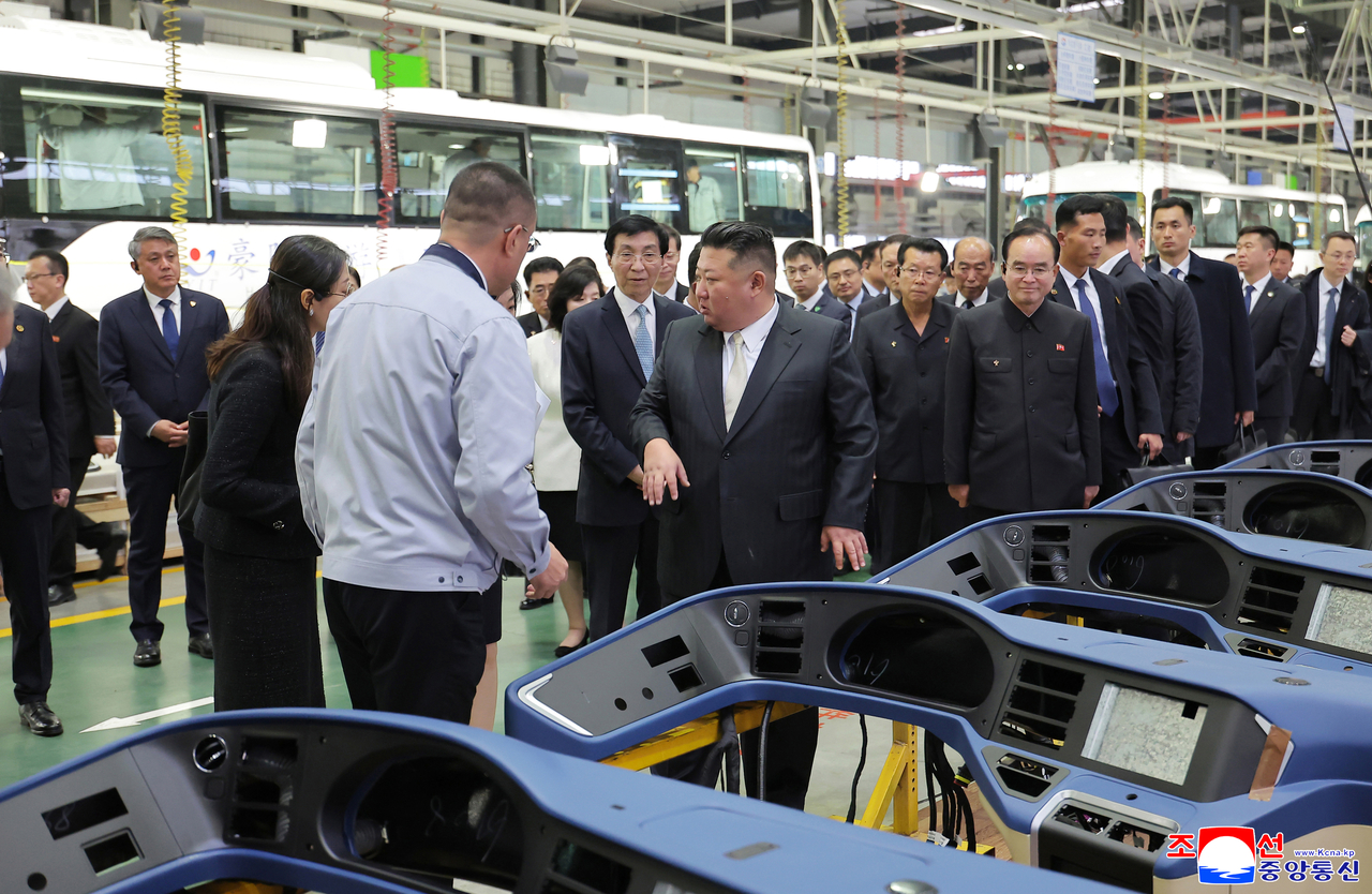 North Korean leader Kim Jong-un (center) inspects parts at an automobile factory in Dandong, Liaoning province, on Oct. 24. (KCNA)
