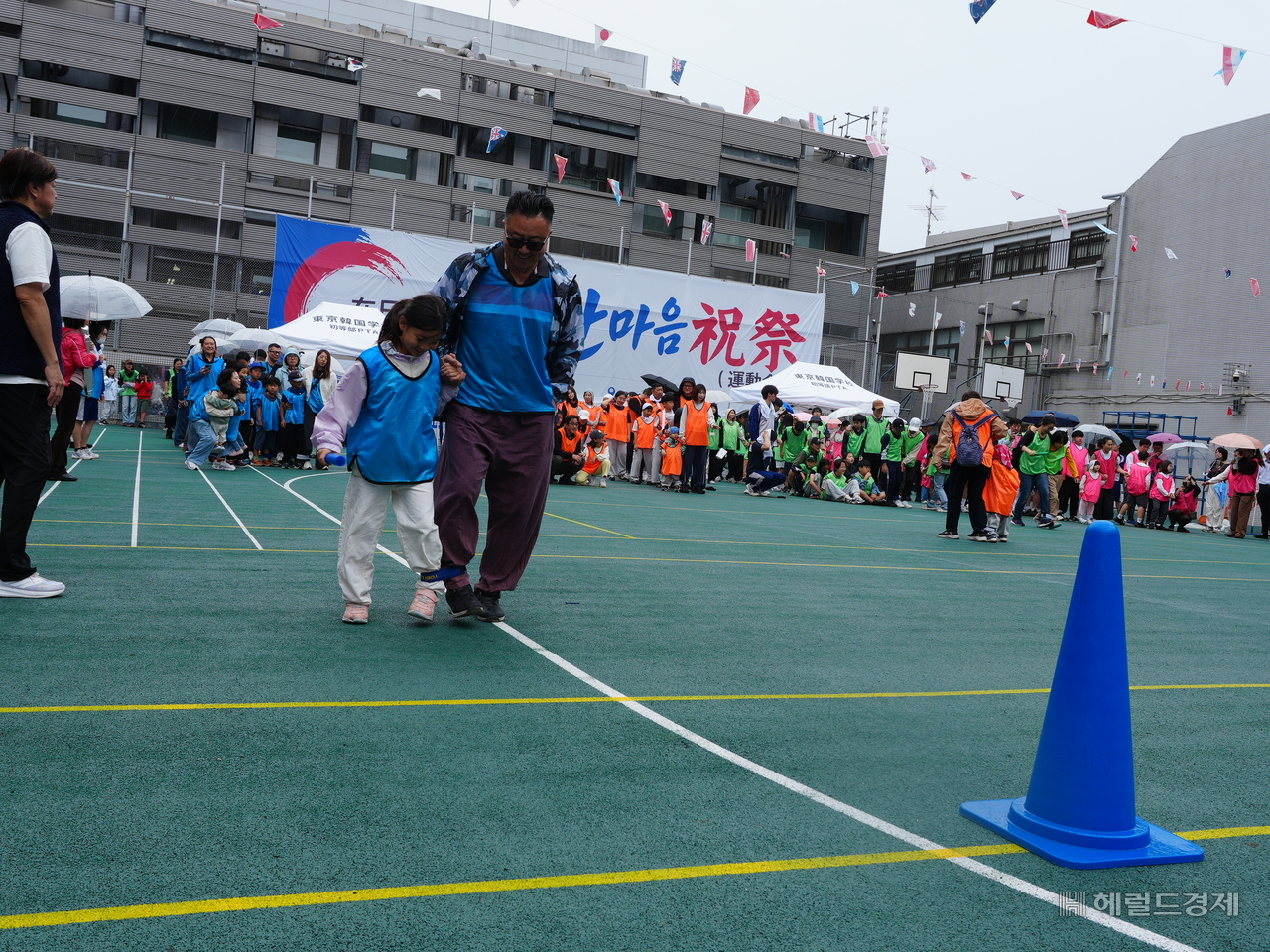 A father-daughter pair takes part in a three-legged race