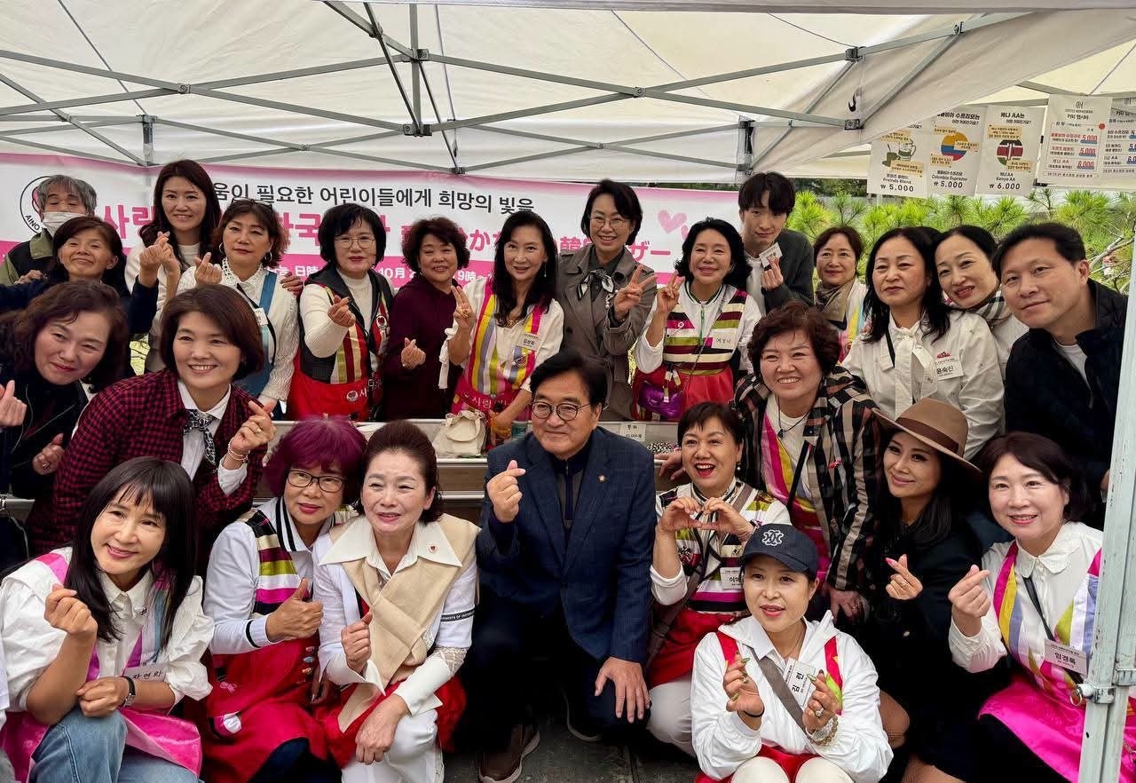 Assembly member Woo Won-shik, a former National Assembly speaker, and Rep. Baek Sun-hee pose for a photo with participants of Sarangeui Nanoom.