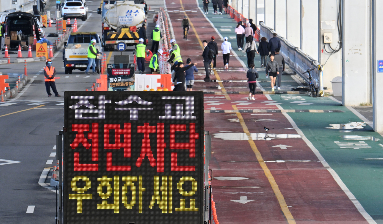 개통 50년을 맞이한 서울 잠수교가 26일 0시를 기해 보행전용교 전환을 위해 차량 통행이 전면 중단됐다. 내년 8월 완공 예정인 보행 전용 잠수교에는 한강 조망 공간 22곳과 투명데크 2곳 등이 조성될 예정이다. 26일  서울 서초구 잠수교 남단에 차량 통제 안내문이 설치돼 있다. 임세준 기자