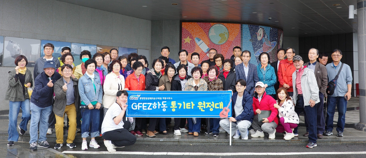 Staff from the Gwangyang Free Economic Zone Authority's Hadong office pose for a group photo with Gopo village residents during their outing. [Hadong office]