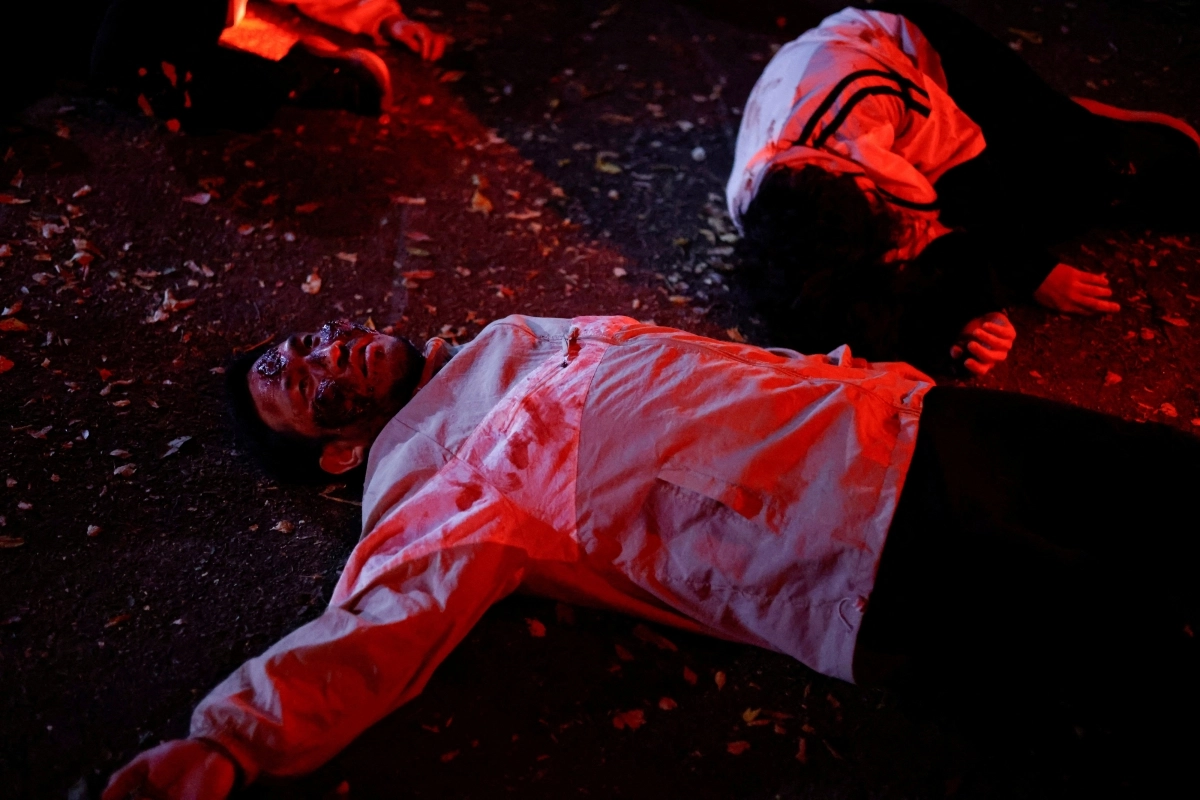 Performers covered in fake blood lie on a street during a zombie-themed program operated by Seoul City Tour Bus on Oct. 20. (Yonhap)
