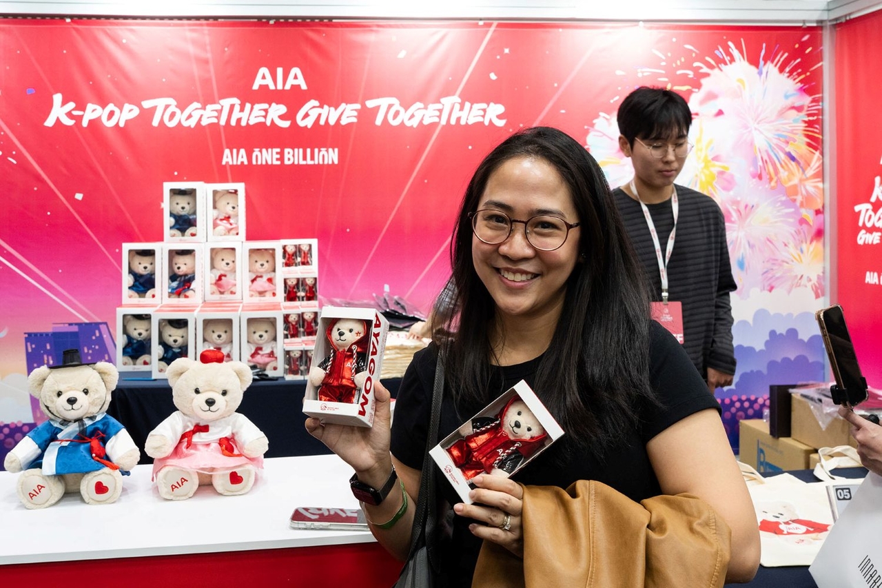 AIA생명은 지난 24일 경기도 고양시 킨텍스에서 열린 ‘K-Pop Together, Give Together’ 콘서트를 성공적으로 개최했다. K-문화체험 존에서 AIA생명의 마케팅 리포터인 아야곰(Ayagom)을 들고 있는 외국인 참가자. [AIA생명]