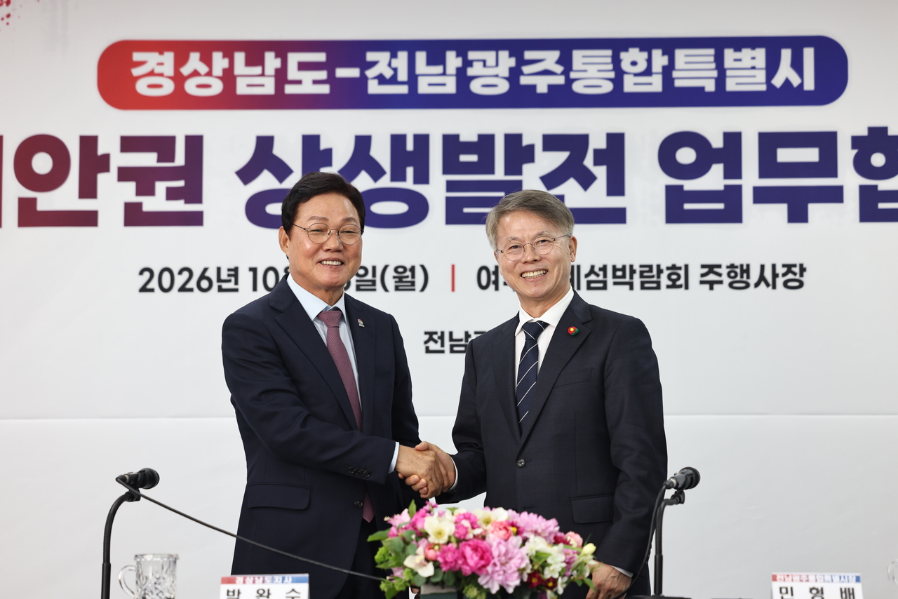 박완수(왼쪽) 경남도지사와 민형배 전남광주통합특별시장이 26일 여수세계섬박람회 주행사장에서 남해안권 상생발전을 위한 업무협약을 체결하고 기념촬영을 하고 있다. [경남도 제공]