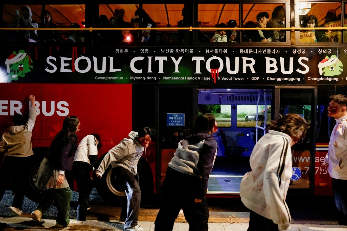 Performers covered in fake blood stagger toward a sightseeing bus like zombies during a zombie-themed program operated by Seoul City Tour Bus on Oct. 20. (Yonhap)