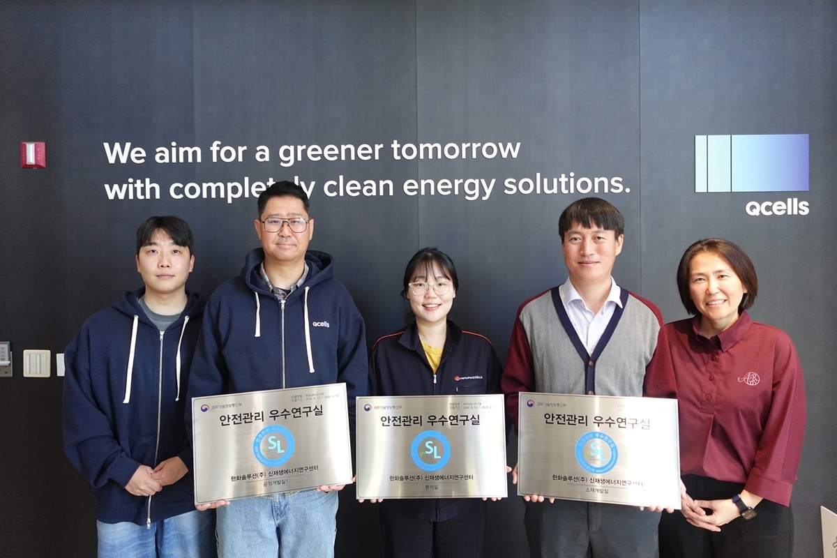 Moon Su-jin (right), head of Hanwha Qcells' Pangyo R&D Center, poses with employees holding a plaque for the Excellence in Laboratory Safety Management certification. [Hanwha Qcells]