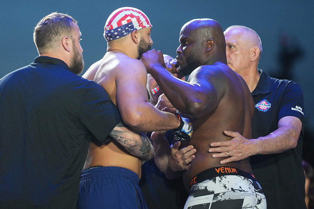 UFC heavyweight fighters Josh Parisian (left) and Derrick Lewis face off at the official weigh-in for UFC Freedom 250, held at the Ellipse near the White House in Washington, D.C., in June. Lewis pressed his fist against Parisian's cheek as officials moved in to separate the two. [Getty Images]