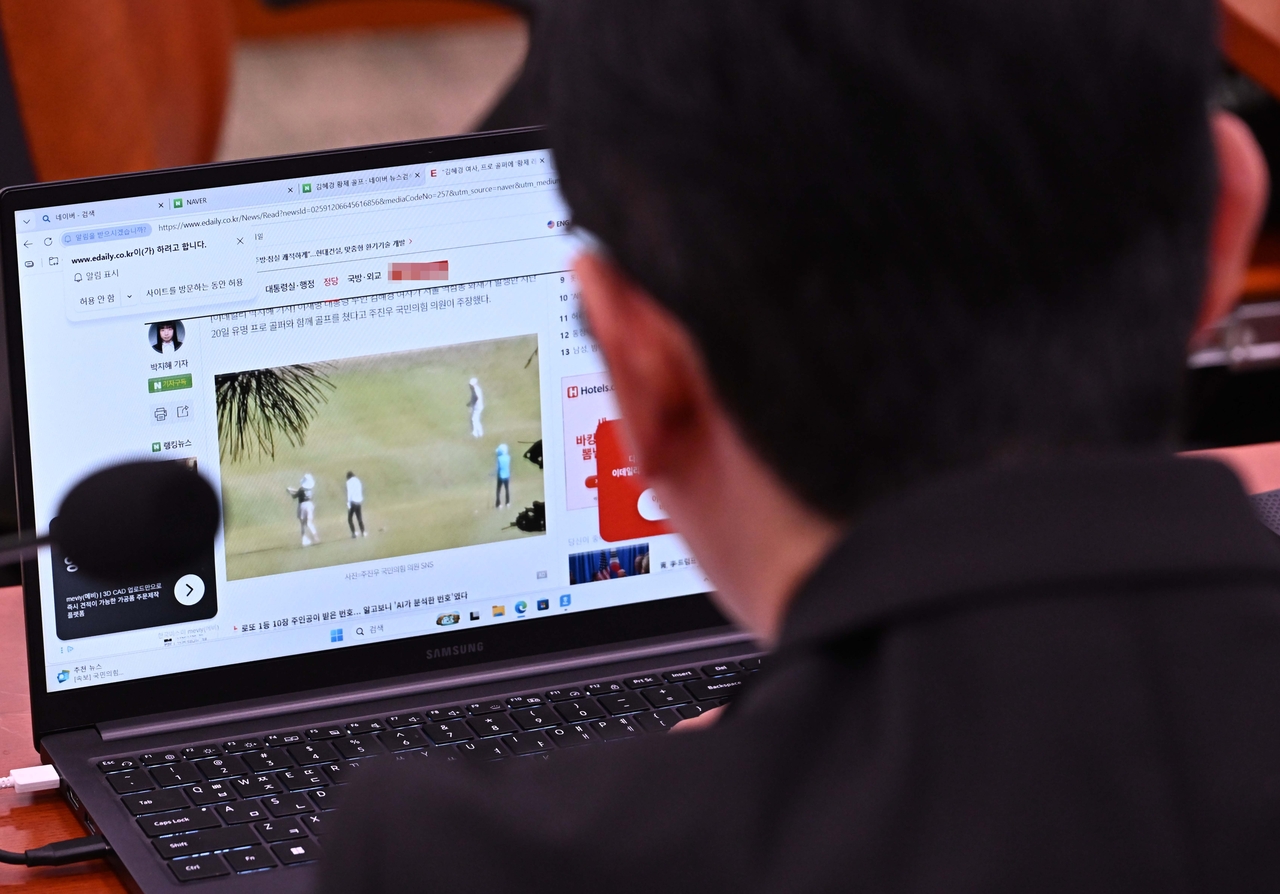 People Power Party lawmaker Joo So-hyun reviews a news article featuring photos he released of first lady Kim Hye-kyung and a professional golfer at a golf outing, during the Legislation and Judiciary Committee's national audit at the National Assembly in Yeouido, Seoul, on Monday. (Lee Sang-sub)