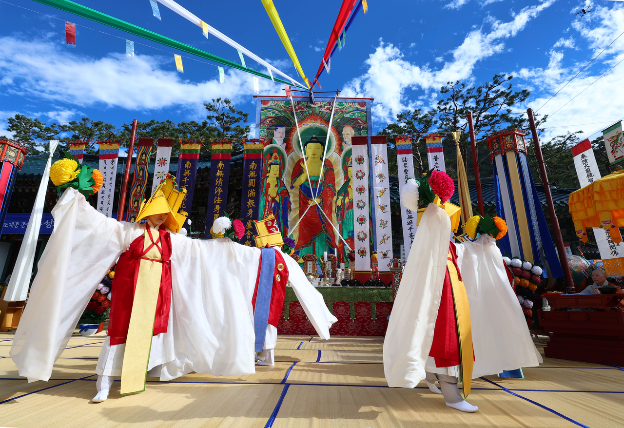 Buddhist nuns holding hanji paper flowers perform the Chakbokmu, a ritual Buddhist dance, during the Jingwansa Gukhaeng Suryukjae — a national intangible cultural heritage ceremony — held at the outdoor ritual grounds in front of the main hall at Jingwansa temple in Eunpyeong-gu, Seoul, on Sunday. Photo provided by Jingwansa temple of the Jogye Order of Korean Buddhism