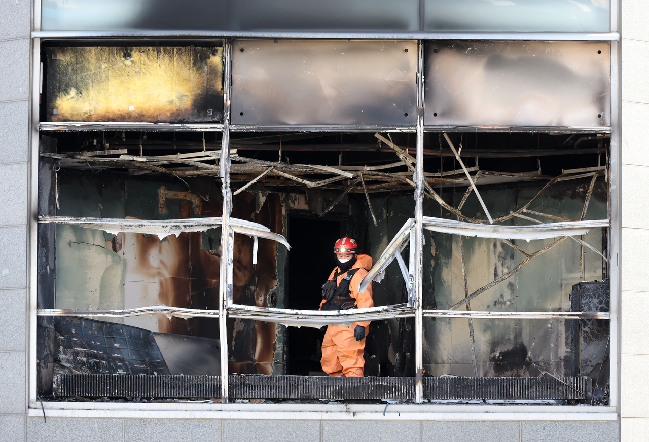 Police and fire department officials conduct a forensic examination at the scene of the arson attacks on two buildings in Yeoksam-dong, Gangnam-gu, Seoul, on Wednesday. [Yonhap]