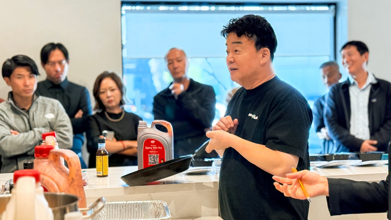 The Born Korea CEO Paik Jong-won (center) demonstrates TBK sauces and prepares dishes for JFC International and Wismettac Asian Foods. (The Born Korea)