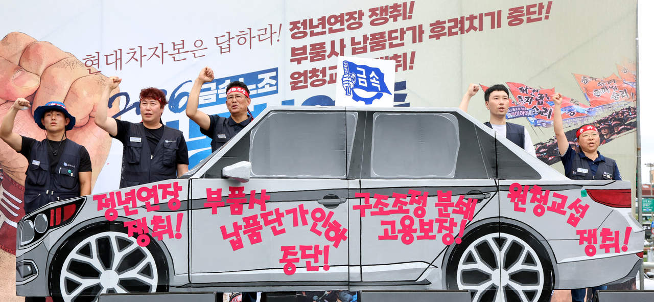 지난 8월 서울 서초구 양재동 현대차그룹 본사 앞에서 열린 금속노조 자동차업종 공동파업 대회에서 노조원들이 모형자동차 뒤에서 구호를 외치고 있다. [뉴시스]