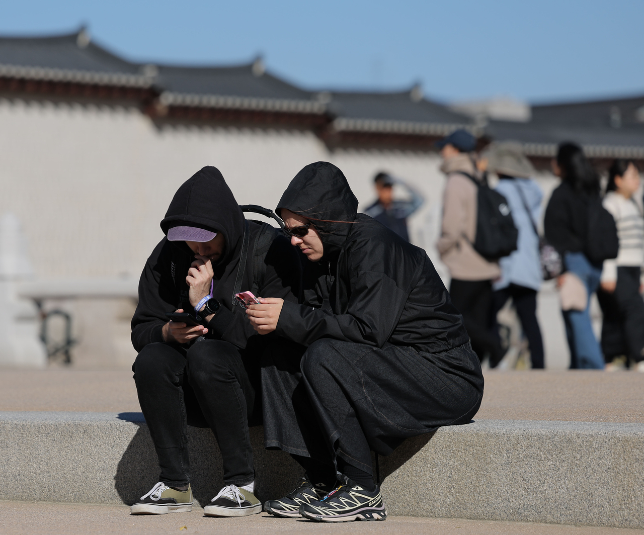 Huddled against the chilly weather at Gyeongbokgung Palace in Seoul on Oct. 21. (Yonhap)