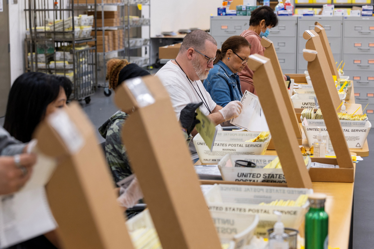 US election workers extract ballots as they help process mail-in ballots at the Registrar of Voters facility in San Diego, Friday. (Reuters-Yonhap)