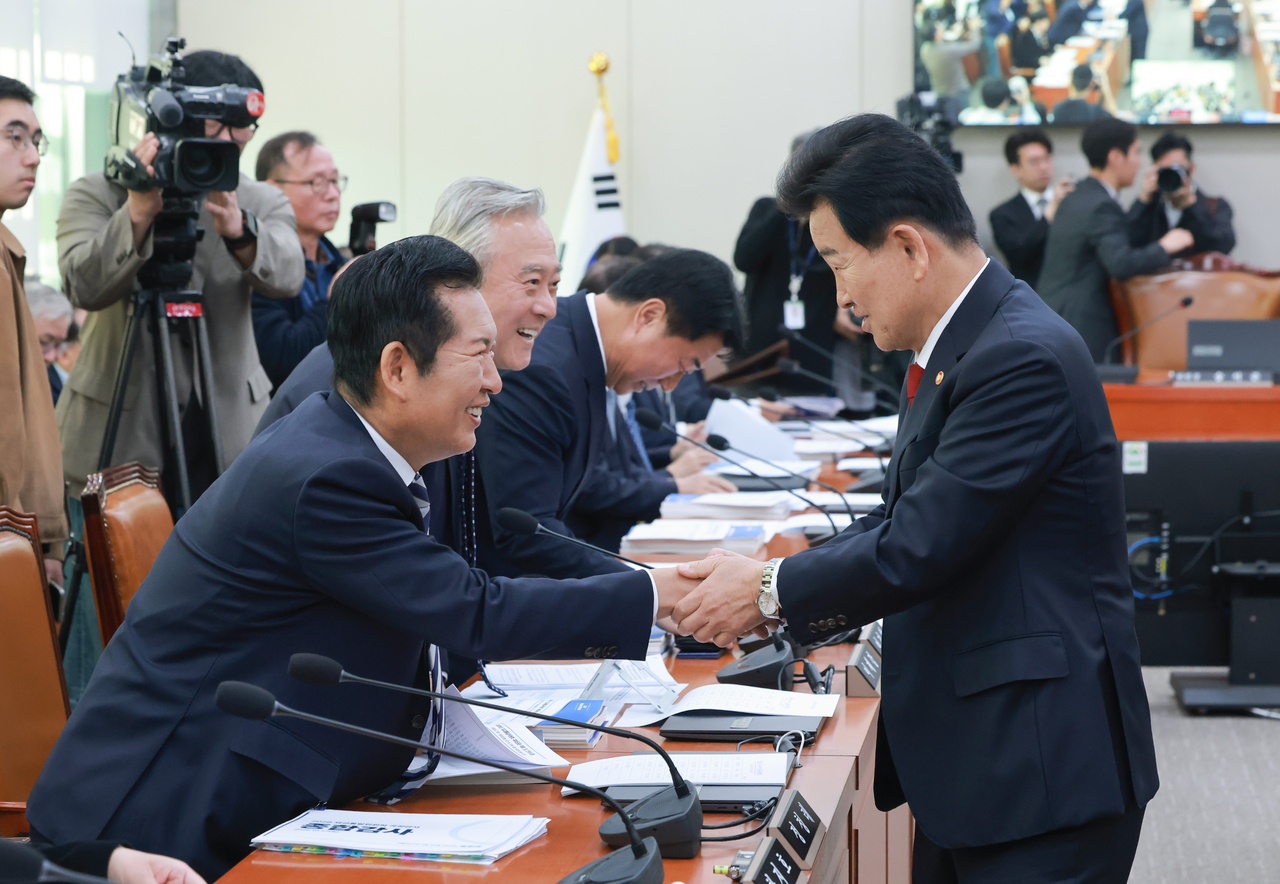 Minister of Unification Jung Dong-young (right) greets Democratic Party of Korea lawmaker Jung Chung-rae as he arrives Tuesday at the National Assembly's Foreign Affairs and Unification Committee for a comprehensive national audit of the Ministry of Foreign Affairs, Ministry of Unification and related agencies. [Yonhap]