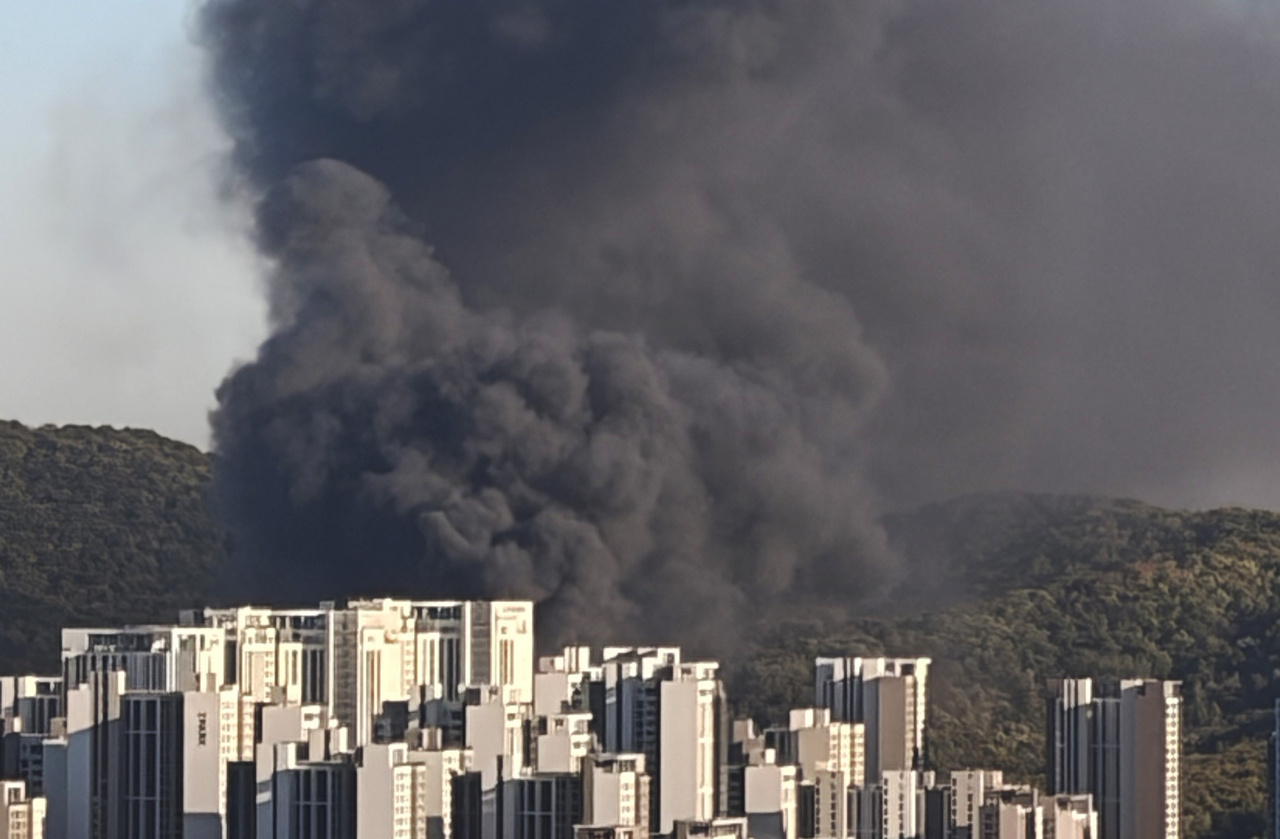 Black smoke billows behind a high-rise residential complex in Seoul on Tuesday. (Yonhap)