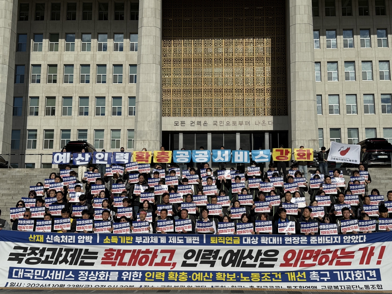 근로복지공단 노동조합 조합원들이 23일 서울 여의도 국회 본관 앞 계단에서 기자회견을 열고 공공서비스 정상화를 위한 인력·예산 확충과 노동조건 개선을 촉구하고 있다. [근로복지공단 노동조합 제공]