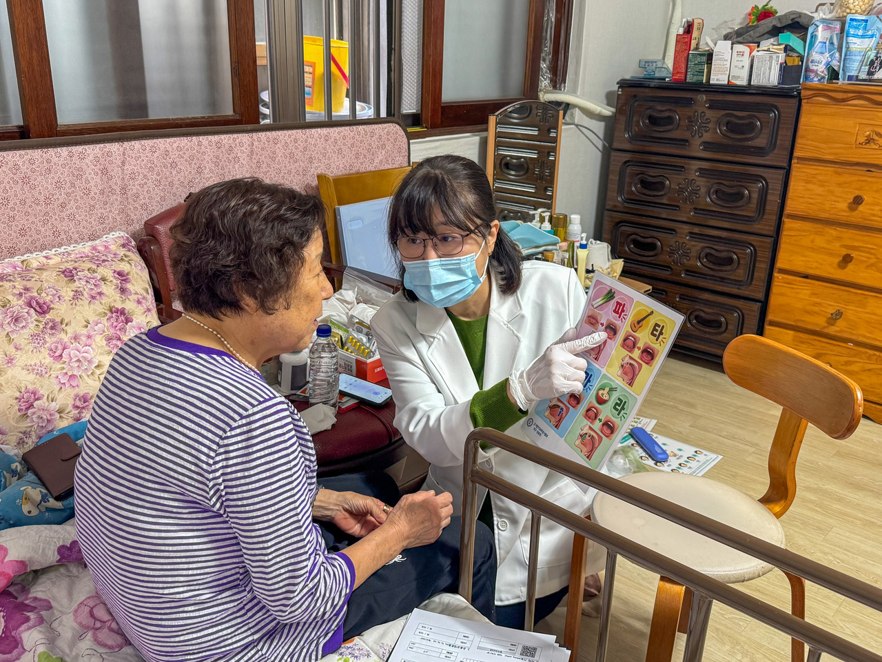 A project staff member checks a patient's oral condition and reviews a customized care plan during a home visit to an integrated care recipient in Gwaneum-dong, Buk-gu, Daegu, on Monday. [Daegu Health College]