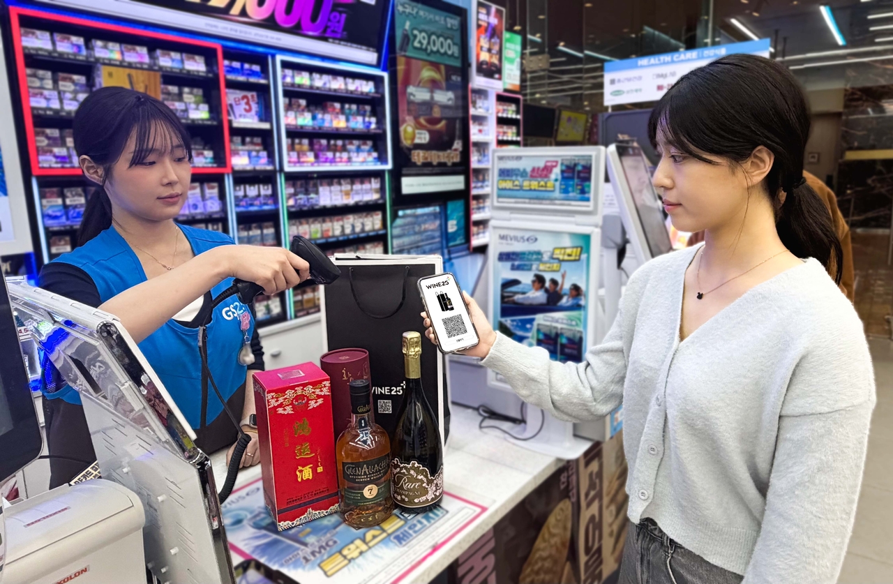 A customer picks up a liquor order placed through Wine25Plus at a GS25 convenience store. [GS Retail]