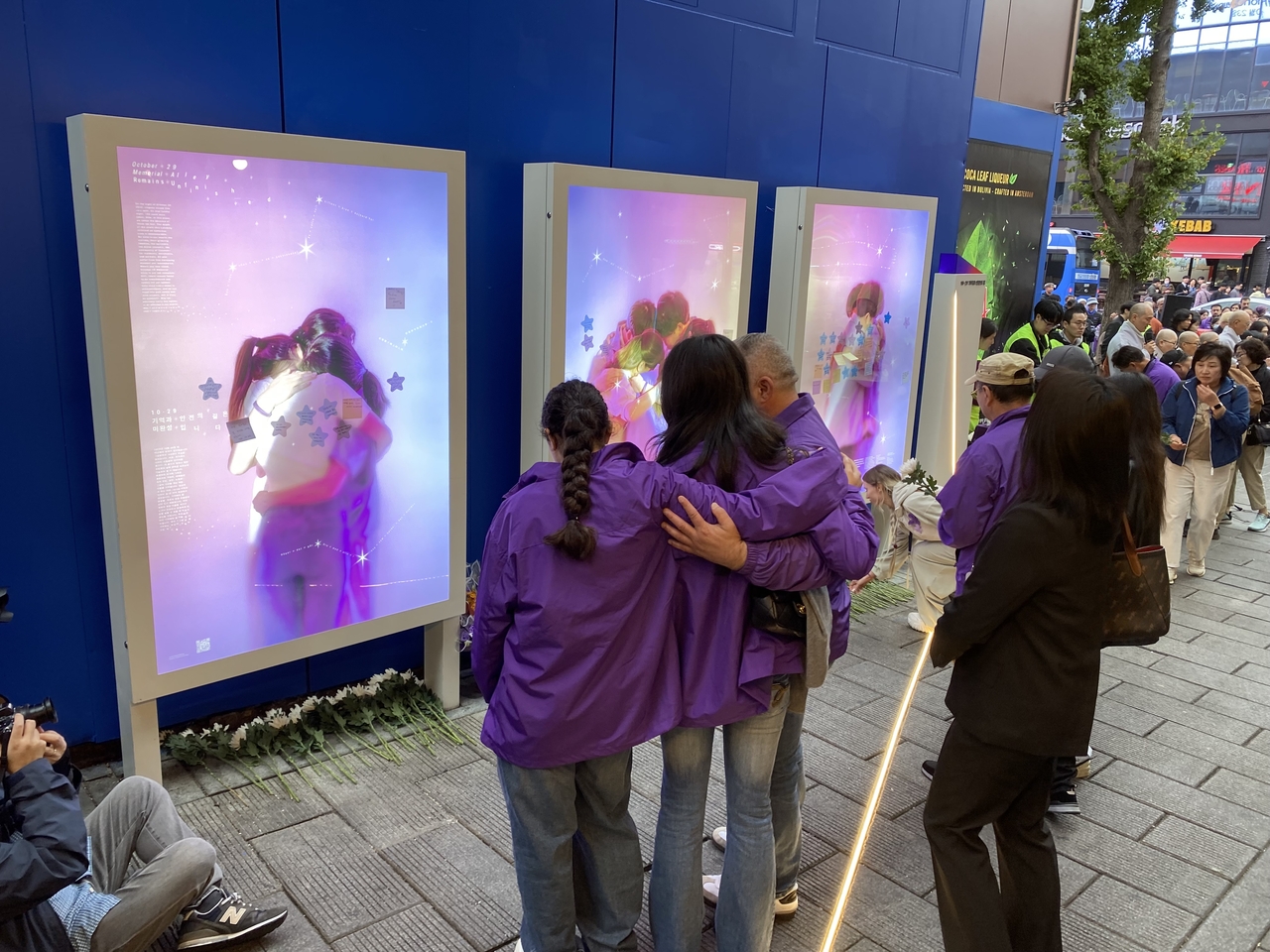 Family members of Grace Rashed, an Australian who died in the 2022 Itaewon crowd crush, comfort one another in front of a memorial site for the disaster in Itaewon, central Seoul, on Saturday. (Lim Jae-seong/The Korea Herald)