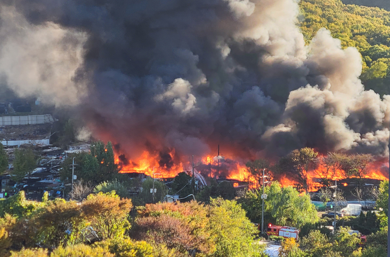 Flames and smoke rise from Guryong Village in Gangnam-gu, southern Seoul, as a fire sweeps through the settlement Tuesday. (Yonhap)