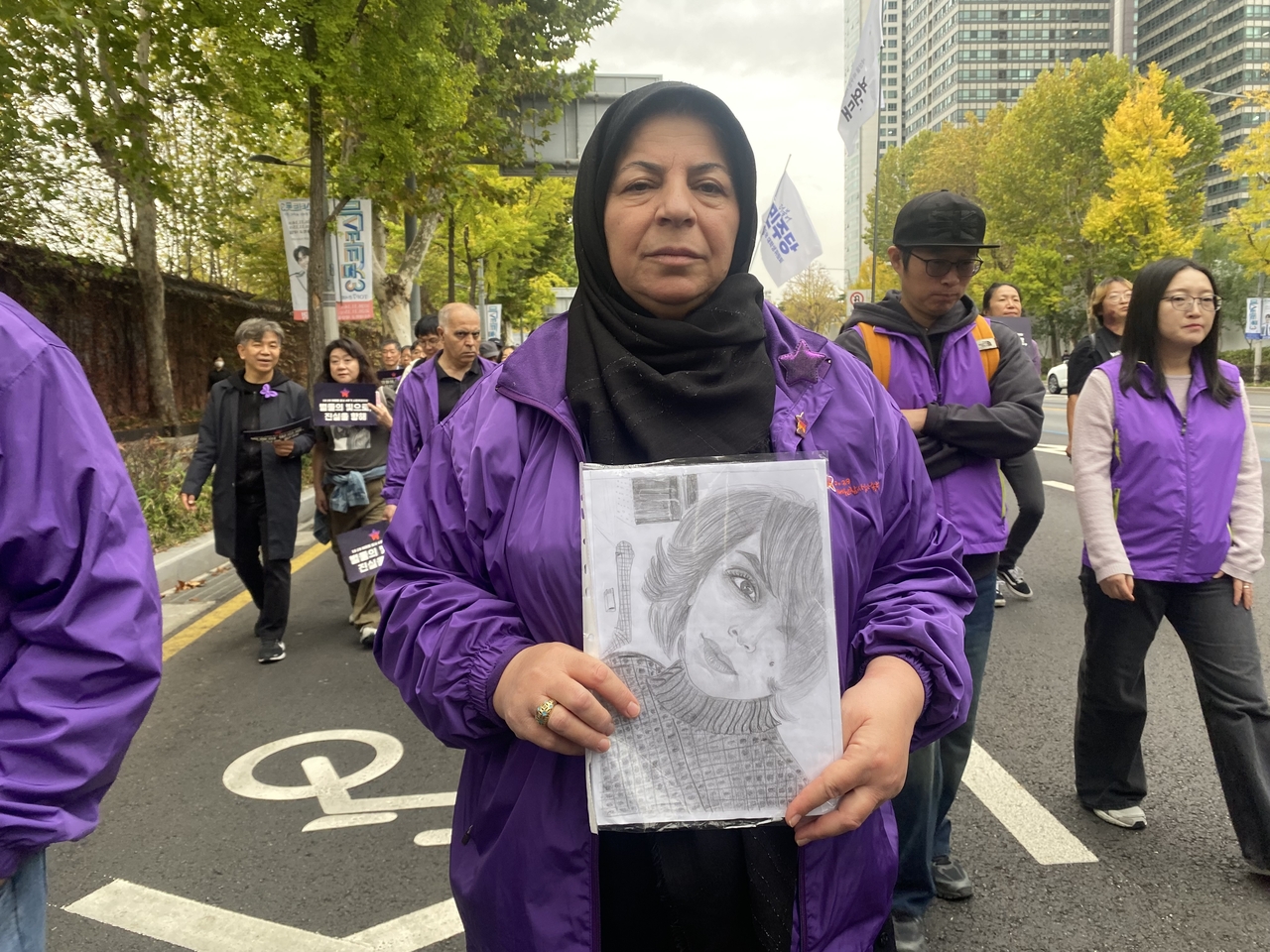 Zahra Rezaei from Iran marches with a portrait of her daughter, Afagh Rastamesh, who died in the 2022 Itaewon crowd crush, during a march marking the disaster’s fourth anniversary in central Seoul on Saturday. (Lim Jae-seong/The Korea Herald)