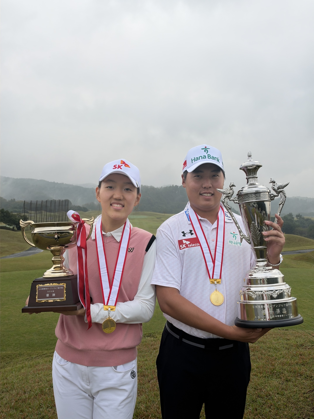 Lee Seung-min (right) and Kim Seon-yeong pose with their winner's trophies.