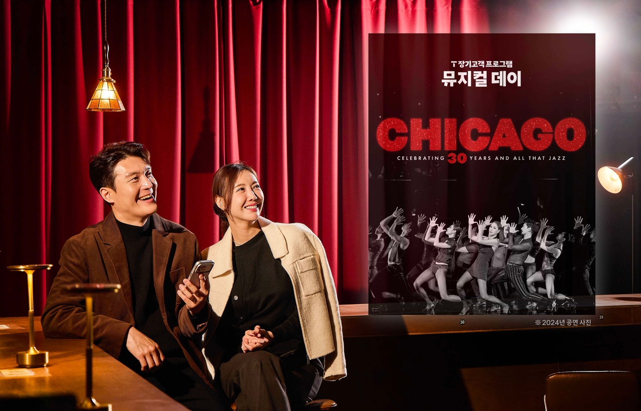 SKT 모델들이 ‘T 장기고객 프로그램 뮤지컬 데이’ 이벤트 페이지를 살펴보고 있다.[SK텔레콤 제공]