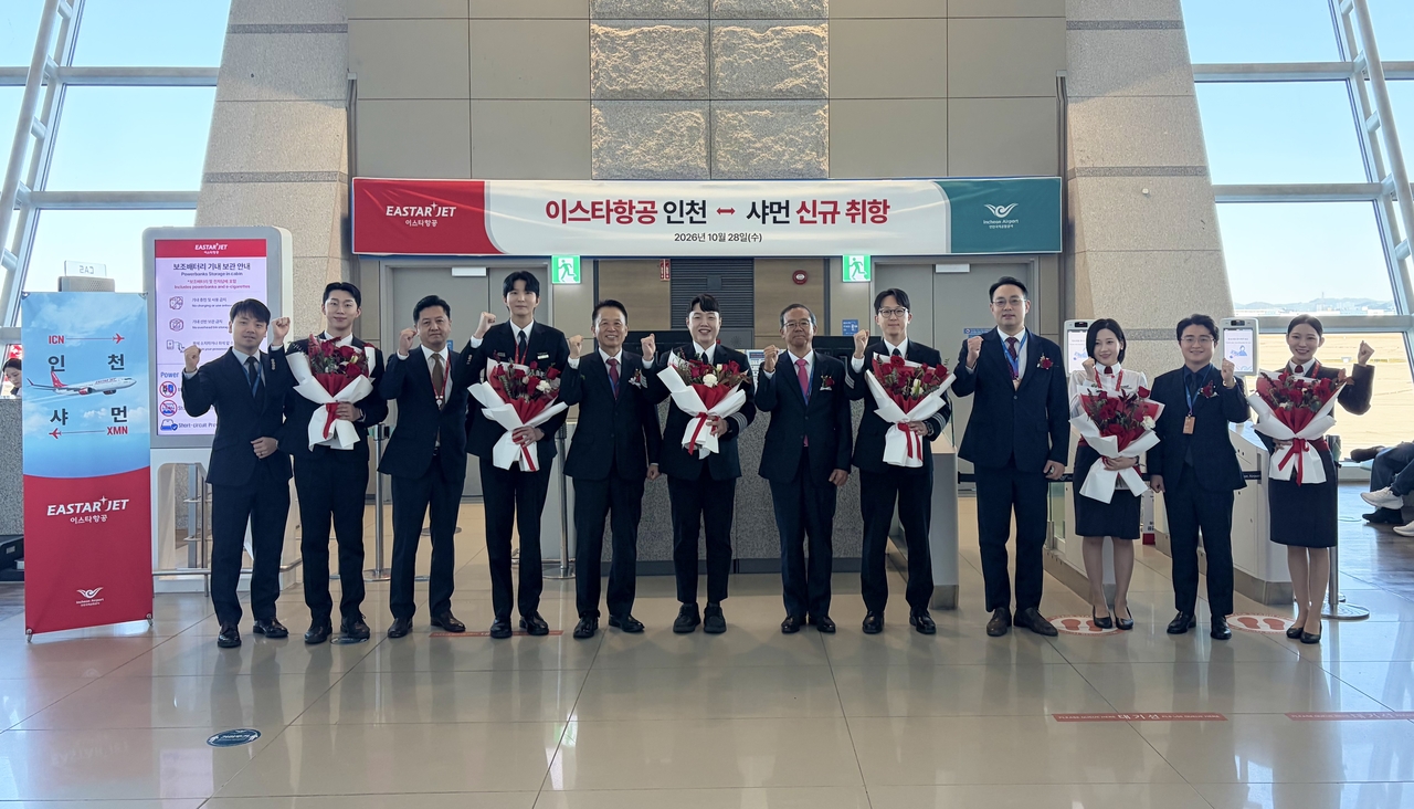 Eastar Jet CEO Jo Jung-seok (sixth from right) and other executives pose for a commemorative photo at Incheon International Airport on Wednesday to mark the inaugural flight on the Incheon-Xiamen route. [Eastar Jet]