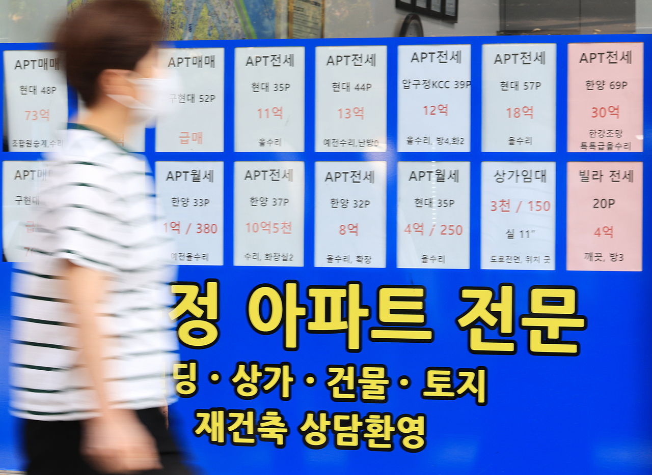 30일 한 시민이 서울 강남구 부동산에 게시된 매매 및 전세 게시물 앞을 지나고 있다. [연합]