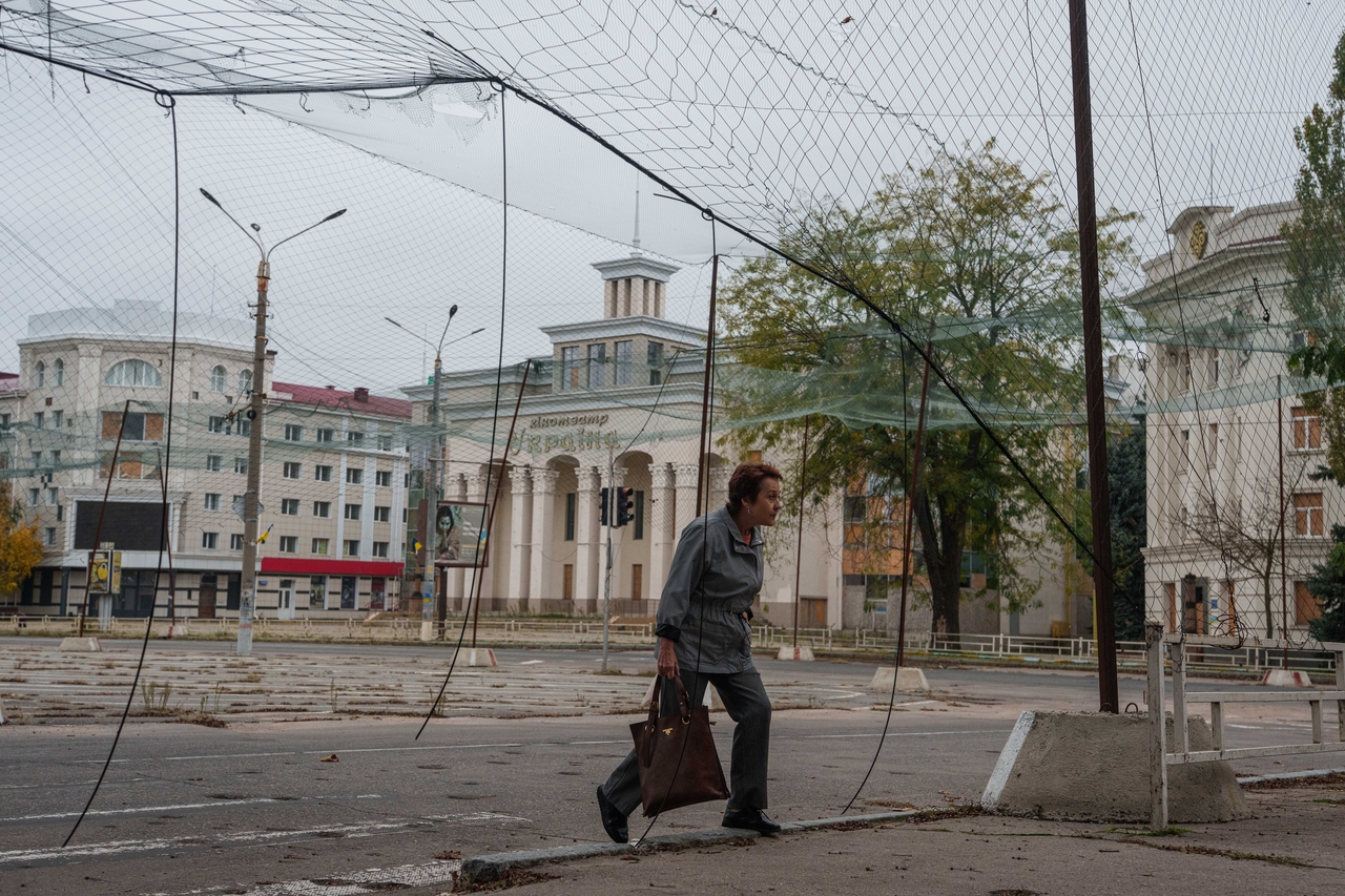 A woman walks on a sidewalk beneath anti-drone nets in Oleshky, Kherson, Ukraine, Tuesday. (AP-Yonhap)