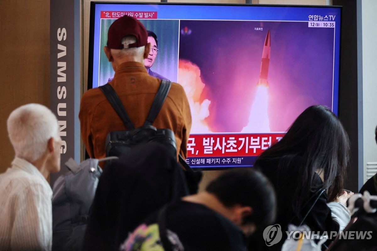 People watch a TV broadcasting a news report on North Korea firing multiple ballistic missiles toward the sea off its east coast, at a railway station in Seoul, in this October 12. (Yonhap)