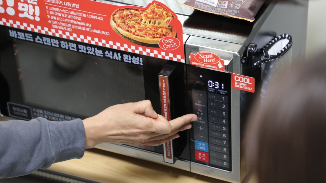 A staff member demonstrates the Smart Cooker at BGF Foods' food center in Jincheon, North Chungcheong Province, on Wednesday. [BGF Retail]