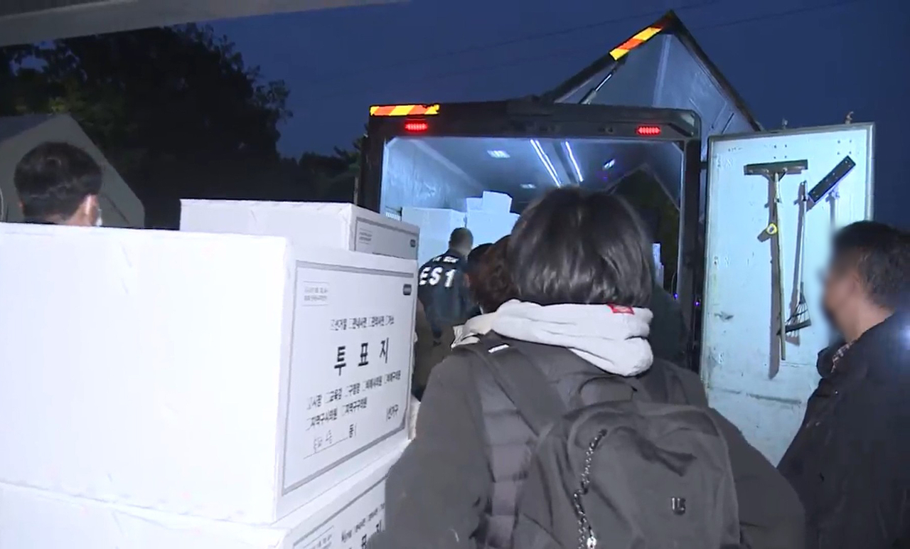 This image provided by Yonhap News TV shows ballot boxes being transported from the Olympic Park Handball Gymnasium in southeastern Seoul on Thursday, following an inspection by a special counsel team. (Yonhap)