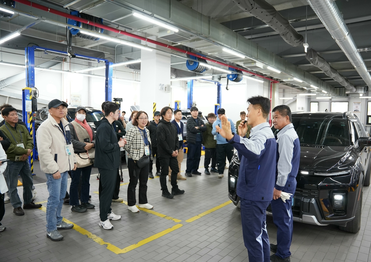 A KGM service center staff member explains vehicle maintenance tips to attendees at the KGM Service Customer Appreciation Event held Wednesday at the KGM Regional Service Center in Gunpo. [KGM]