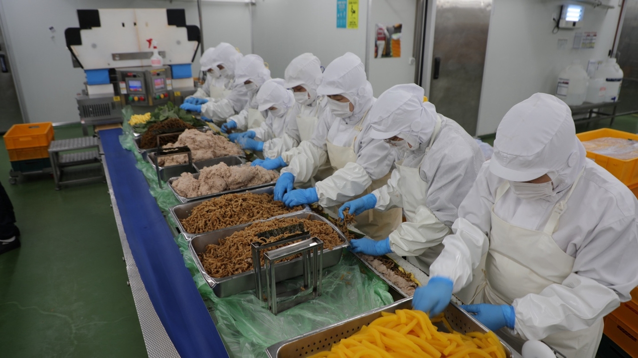 Workers make kimbap at BGF Foods' food center in Jincheon, North Chungcheong Province, on Wednesday. [BGF Retail]