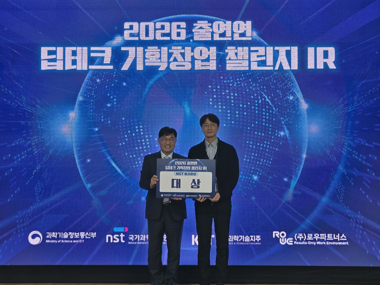 Park Seung-cheol (right), a researcher at the Korea Institute of Machinery and Materials, and Min Byeong-gwon, head of NST's research strategy division, pose for a photo after Park's team won the grand prize at the 2026 Deep Tech Startup Challenge IR. [NST]