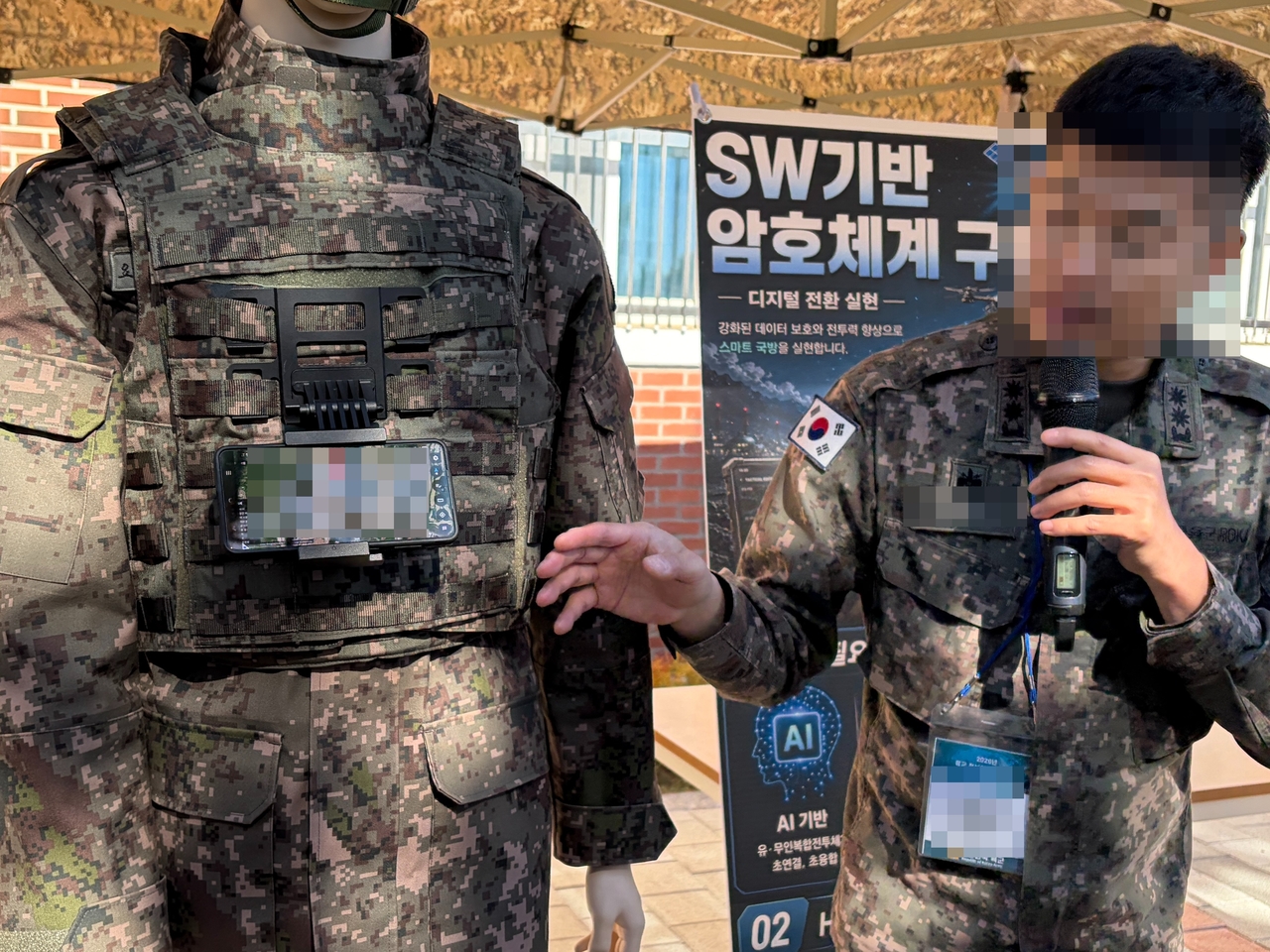 A South Korean Army official demonstrates an on-device AI system installed on a smartphone-like device attached to the chest of a mannequin in military uniform at the 9th Infantry Division in Goyang, Gyeonggi Province, on Wednesday. (Hwang Joo-young/The Korea Herald)